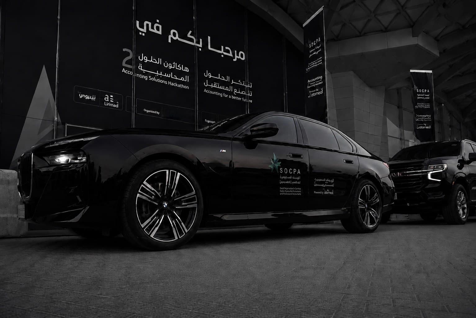 سيدان تنفيذية تحمل هوية الفعالية عند مدخل المؤتمر