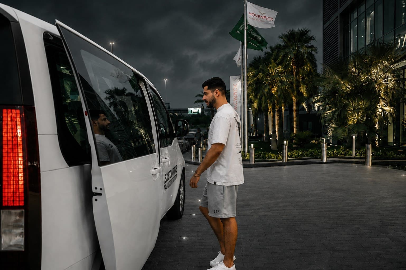 ضيف يصعد إلى مركبة نقل تنفيذي من عزم أمام مدخل الفندق